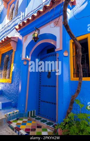 Porta d'ingresso blu, pavimento d'ingresso decorato con piastrelle a mosaico di diversi colori Foto Stock