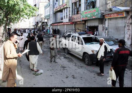 I funzionari della sicurezza cadono fuori sede dopo un'esplosione nei pressi di un veicolo della polizia, a Quetta, lunedì 10 aprile 2023. Quattro persone, tra cui due poliziotti lunedì, sono state martirizzate dopo un'esplosione nei pressi di un veicolo di polizia nella zona di Shahrah-e-Iqbal di Quetta. Foto Stock