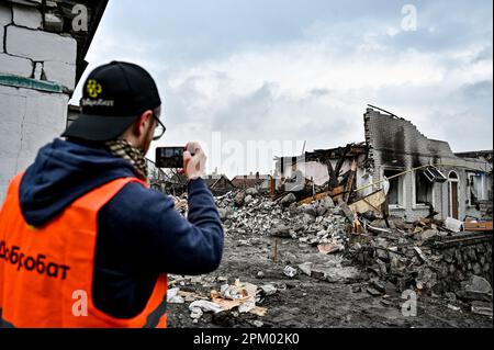 ZAPORIZHZHIA, UCRAINA - 9 APRILE 2023 - Un uomo scatta foto delle rovine di una casa distrutta nello sciopero del razzo dell'esercito russo, Zaporizhz Foto Stock