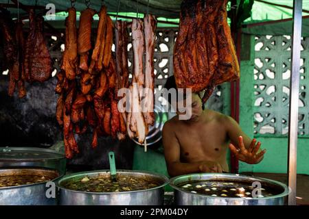 Yangon, Myanmar. 10th Apr, 2023. Un venditore trita carne per strada in Yangon. Il 1 febbraio 2021, il governo della giunta militare (Tatmadaw) ha preso il potere con il colpo di stato, incarcerando il governo della NLD (Lega Nazionale per la democrazia) democraticamente eletto e gettando il paese in una crisi umanitaria in corso, descritta da molti come una guerra civile o l'rivolta popolare. Credit: SOPA Images Limited/Alamy Live News Foto Stock