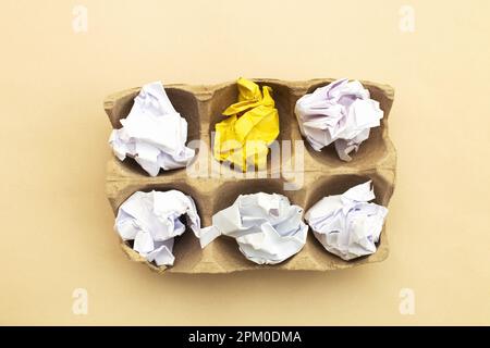 carta bianca e gialla sminuzzata in scatola di cartone per uova come idea creativa e innovazione concettuale. Concetto di idee di Pasqua Foto Stock