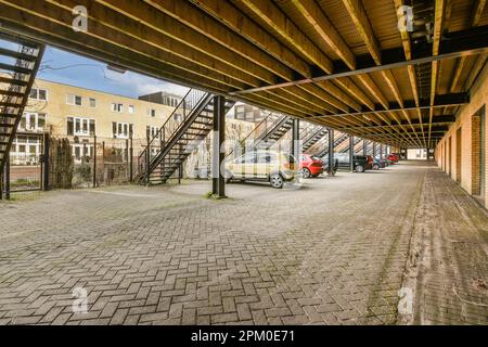 un'auto parcheggiata in un parcheggio vuoto con scale che portano all'ultimo piano e due auto su entrambi i lati Foto Stock