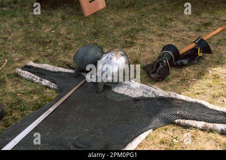 Kaiserslautern, Germania. 10th Apr, 2023. Due caschi medievali in acciaio, guanti, una spada e una blindatura leggera appoggiati a terra a scopo dimostrativo. Credit: Gustav Zygmund/Alamy News Foto Stock