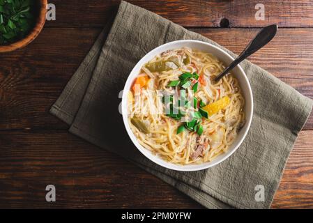 Ciotola bianca di zuppa di noodle dell'anatra con verdure. Vista dall'alto Foto Stock