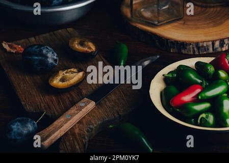 Peperoni di susina e Jalapeno per la cottura della marmellata piccante Foto Stock