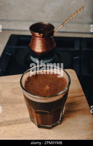 Bicchiere di caffè turco preparato in rame Cezve in stufa Foto Stock