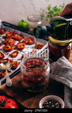 Conserve di pomodoro con timo e aglio in olio d'oliva in vaso di vetro Foto Stock