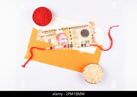 Rakhsha bandhan concetto rakhi con riso kumkum e denaro Foto Stock