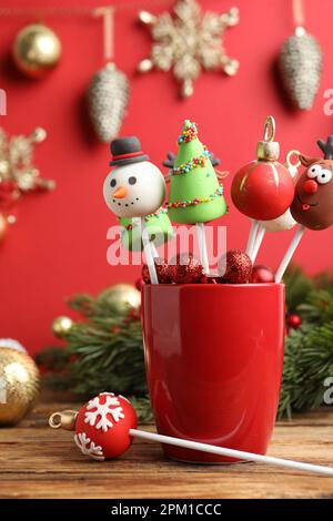 Deliziosi dolci natalizi a tema pops su tavolo di legno Foto Stock