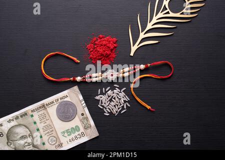 Vista dall'alto del lussuoso rakhi con roli e valuta indiana Foto Stock