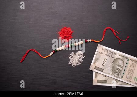 Vista dall'alto di rakhi con soldi e kumkum Foto Stock