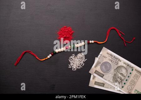 Vista dall'alto di rakhi con soldi e kumkum, concetto di bandhan di raksha Foto Stock