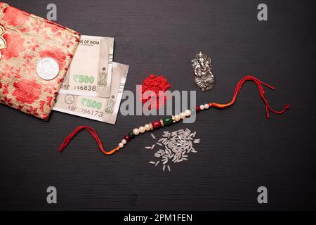 Vista dall'alto di rakhi con soldi e roli Chawal Foto Stock