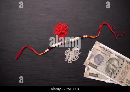 Rakhi con soldi indiani e kumkum Foto Stock