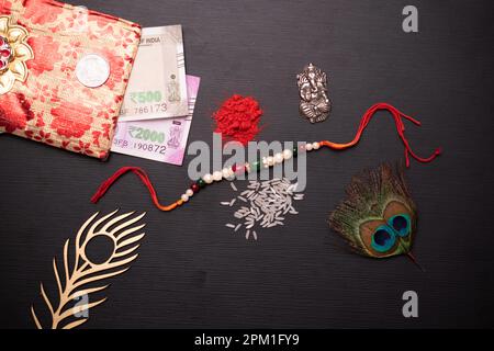 Vista dall'alto di rakhi con soldi e kumkum sul tavolo, concetto di bandhan di raksha Foto Stock