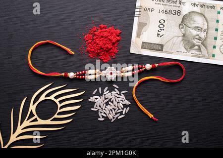 Rakhi con vista sul kumkum e sul denaro Foto Stock