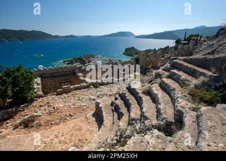 La vista dalle rovine dell'antico teatro all'interno della fortezza crociata di Simena che si trova sopra la città mediterranea di Kalekoy a Turkiye. Foto Stock