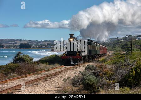 VICTOR HARBOR, SOUTH AUSTRALIA, AUSTRALIA - 10 APRILE 2023 : il treno Cockle guidato da Engine RX 224, una locomotiva a vapore costruita nel 1915, viaggia lungo il Th Foto Stock