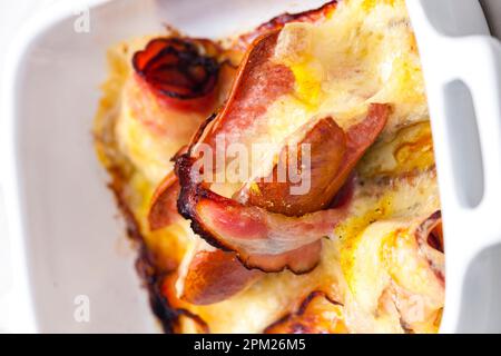 wurst in pancetta al forno con formaggio chedar Foto Stock