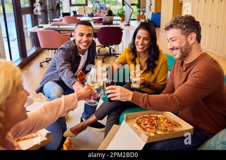 Il personale dell'informale Meeting in Office con pizza Takeaway e bevande Foto Stock