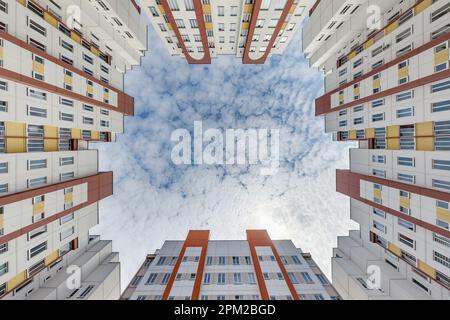 guarda da terra al cielo blu tra i grattacieli, guarda la casa dal basso verso l'alto Foto Stock