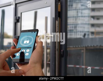 Immagine ritagliata della femmina che immette codice chiave segreto per ottenere l'accesso e passare edificio utilizzando l'applicazione sul telefono cellulare, donna premendo i pulsanti su Foto Stock