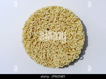 Spaghetti istantanei grezzi su sfondo bianco - spaghetti istantanei rotondi Foto Stock