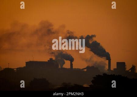 Fabbrica con camino di fumo ai margini del parco nazionale di Kruger, Mpumalanga, Sudafrica. Foto Stock