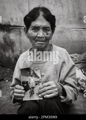 Una vedova anziana della minoranza etnica Jerai negli altopiani centrali del Vietnam, tiene una fotografia del suo defunto marito, il capo del villaggio, presa Foto Stock