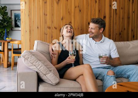 giovane coppia datazione. uomo e donna seduti in divano e flirtare mentre beve un cocktail Foto Stock