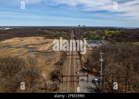 Una vista aerea dei binari del treno a Pelham Bay dalle secche acque paludose di Bronx, New York, durante una mattinata di sole Foto Stock