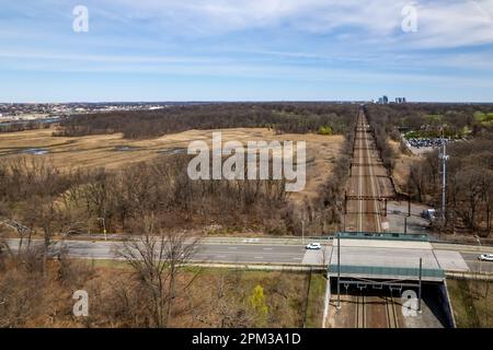 Una vista aerea dei binari del treno a Pelham Bay dalle secche acque paludose di Bronx, New York, durante una mattinata di sole Foto Stock