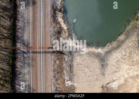 Una vista aerea dei binari del treno a Pelham Bay dalle secche acque paludose di Bronx, New York, durante una mattinata di sole Foto Stock