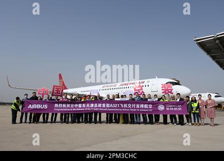 Pechino, Cina-assemblato A321neo aeromobili. 24th Mar, 2023. I membri dello staff del produttore aereo europeo Airbus e Juneyao Air, con sede a Shanghai, che partecipano alla cerimonia di consegna del primo aeromobile A321neo assemblato in Cina, posano per una foto di gruppo di fronte all'aeromobile a Tianjin, nella Cina settentrionale, il 24 marzo 2023. Credit: Zhao Zishuo/Xinhua/Alamy Live News Foto Stock