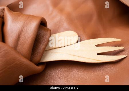 posate di legno avvolte in pelle marrone, primo piano Foto Stock
