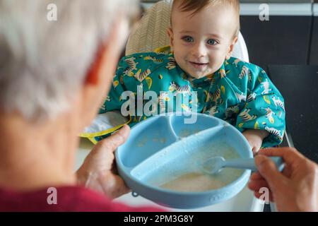 Nonna che alimenta suo nipote Foto Stock