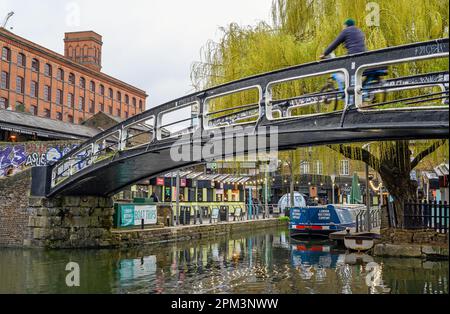 Camden Town, Londra, Regno Unito: Un ciclista su una passerella che attraversa il Regents Canal vicino al Camden Market con un albero di salice. Foto Stock