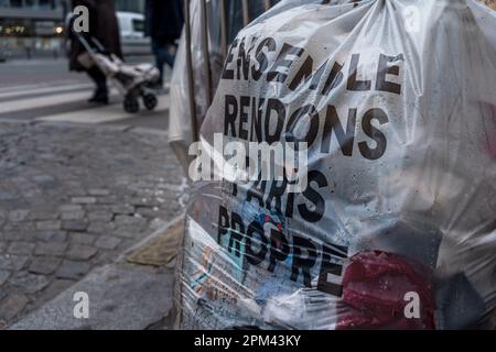 Sacco per spazzatura per strada con 'facciamo Parigi pulita insieme' scritto in francese. Parigi, Francia. Foto Stock