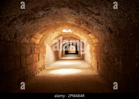 El Jem, Tunisia, 10 gennaio 2023: Corridoio di collegamento nel seminterrato dell'anfiteatro El Jem con scarsa illuminazione Foto Stock