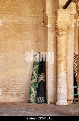 Sousse, Tunisia, 15 gennaio 2023: Arrotolati tappeti di preghiera in un angolo di muratura in pietra naturale nella Grande Moschea di Sousse Foto Stock