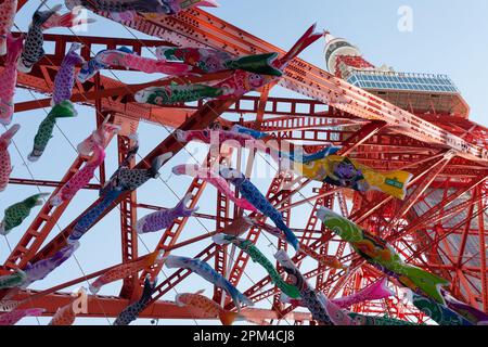 Alcuni dei 333 Koinobori, o Carp Streamers, in mostra alla Tokyo Tower prima della celebrazione del giorno dei Bambini. La giornata dei bambini è una festa nazionale in Giappone celebrata il 5th maggio. In origine un giorno per i bambini di desiderio sia la felicità che la salute è ora un giorno che celebra tutti i bambini. In questo periodo dell'anno i Koinobori tradizionali (bandiere di carpa o streamers) sono volati dalle case con ogni bandiera che rappresenta un membro della famiglia. Foto Stock