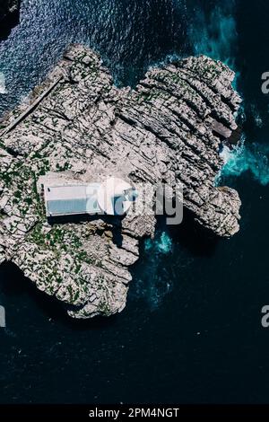 Vista aerea dall'alto verso il basso del faro e dell'isola di Mouro all'ingresso della baia di Santander in Spagna Foto Stock