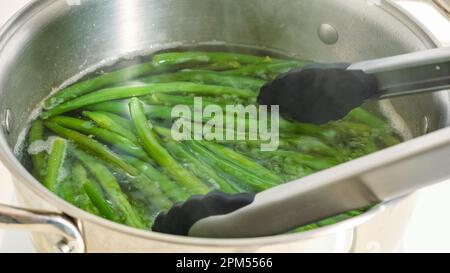 Ricetta di fagioli verdi francesi fritti in padella (Haricots Verts). Lessare i fagioli verdi prima di soffriggerli. Foto Stock