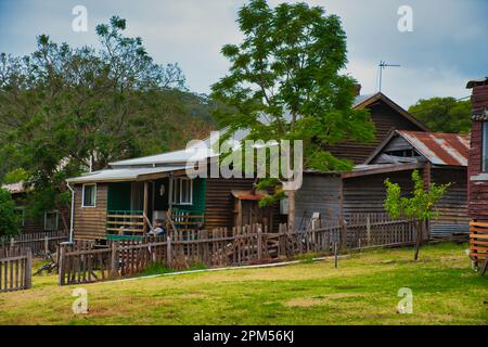 Vecchio, piuttosto trascurato Weatherboard cottage con una recinzione rotta in una piccola città australiana Foto Stock