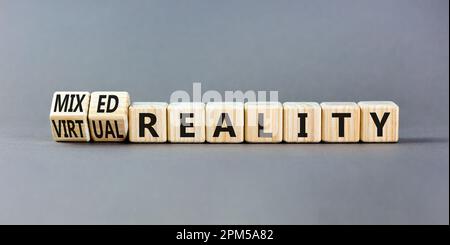 Simbolo di realtà mista o virtuale. Parole di concetto realtà mista realtà virtuale su cubi di legno. Bellissimo sfondo grigio tavolo. Business misto o. Foto Stock