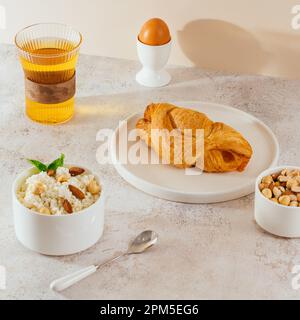 latte in un bicchiere, cialde cremose su un piatto su un tavolo di legno Foto Stock