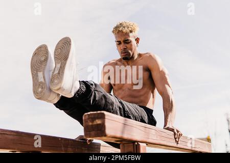 Foto di scorta di un uomo nero che fa calistenics in un parco Foto Stock