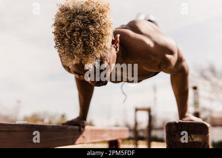 Foto di scorta di un uomo nero che fa calistenics in un parco. Foto Stock