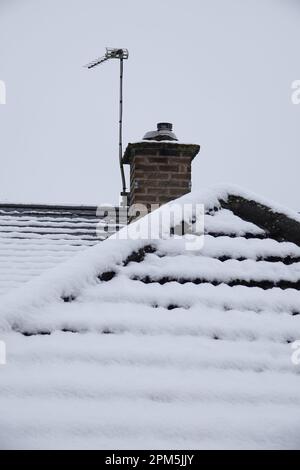 Un tetto innevato e camino Foto Stock