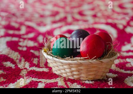 Uova di Pasqua dipinte di colore rosso su sfondo primaverile. Buona Pasqua. Foto Stock